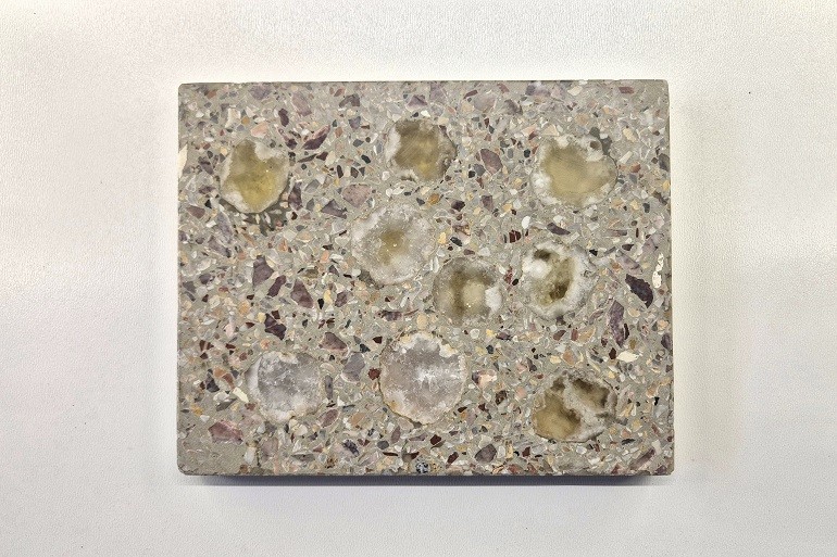 Grijs terrazzo met doorgeslepen natuurlijke geodes en zichtbare kristalstructuren.