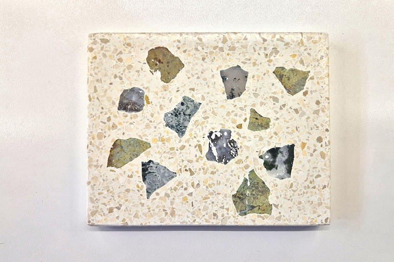 Lichte terrazzo met verschillende aangesneden brokken dendritisch gesteente.